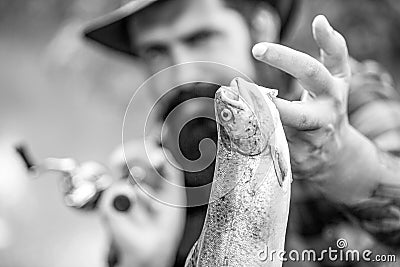 Fishing backgrounds. Man hold big fish trout in his hands. Fisherman and trophy trout. Man holding a trout fish. Black Stock Photo