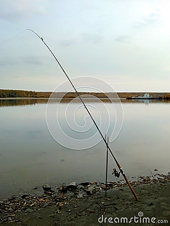 Fishing. Beautiful summer landscape with river and feeder fishing rod on the rocky shore Stock Photo