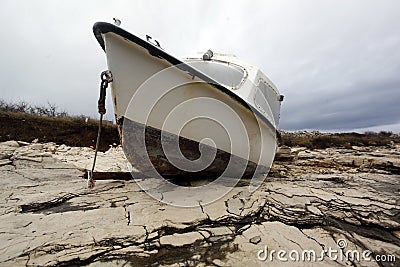 Fishing boat beached on a rock Stock Photo