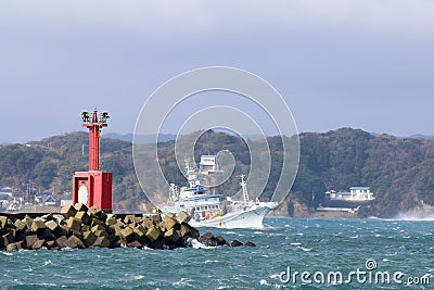 Japanese tuna Boat escaping a Typhoon by coming into port with a wonderful rainbow in the sky. Editorial Stock Photo