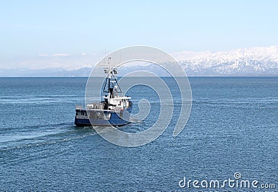 Fishing boat going out to sea Stock Photo