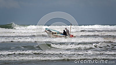 Fishing boat launching from the beach Stock Photo