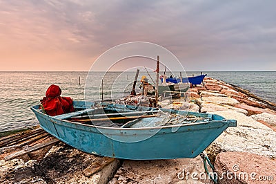Fishing boat moored on cliff at sunset. Stock Photo