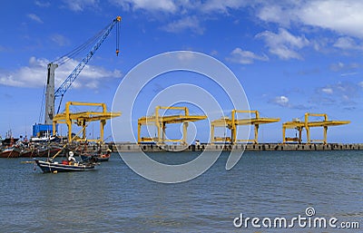 Fishing boat parking at industry cranes Stock Photo