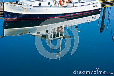 Fishing boat reflection at public marina Stock Photo