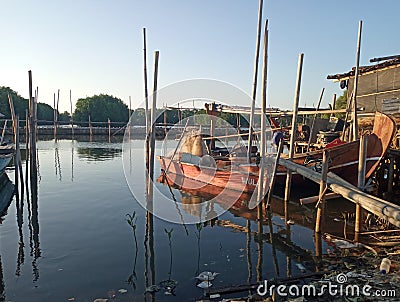 The fishing boat rests next to the riverside house in the evening. Tangerang Indonesia, July 14 2023. Editorial Stock Photo
