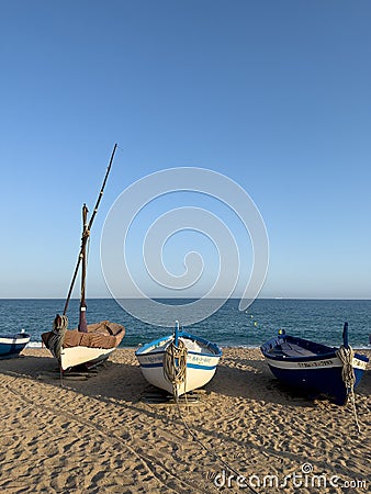 Fishing boat on sandy beach at sunset in Pineda de Mar, Spain Editorial Stock Photo