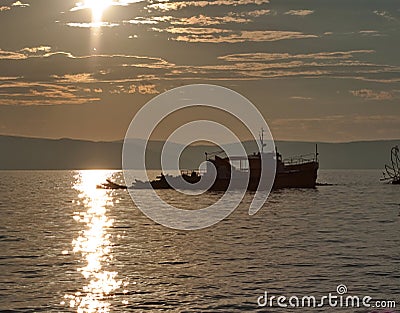 Fishing boat in sea at sunset Stock Photo