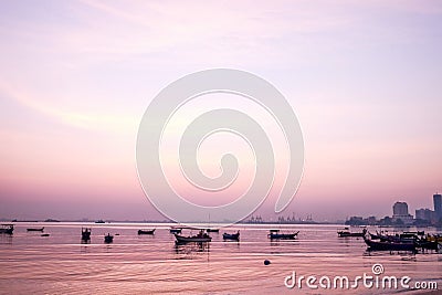 Fishing boat silhouette with orange sunrise sky and water reflection Stock Photo