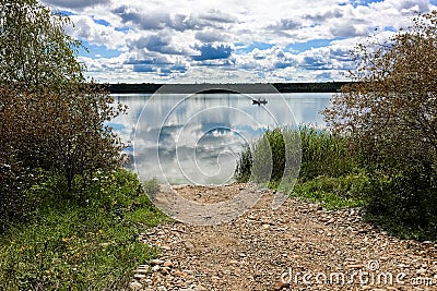 A fishing boat silhouetted on a calm lake Stock Photo