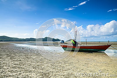 Fishing boat on wavy sand beach Stock Photo