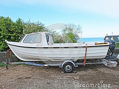 Fishing Boat white on a trailer concrete yard. fish Editorial Stock Photo