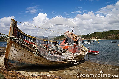 Fishing boat wrecked into a rocky river bank Stock Photo