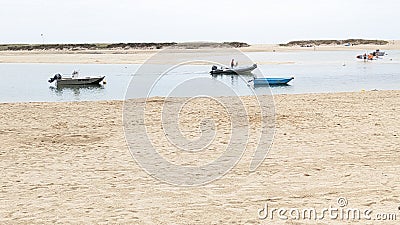 Fishing boats anchored off a beach in an estuary in Benodet Stock Photo