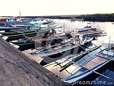 Fishing boats dock at at fish port or pier and replenish their supplies before heading out to sea again. Editorial Stock Photo