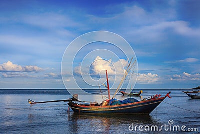 Fishing boats float in the blue sea in the evening. Stock Photo