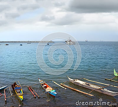 Fishing boats in the ocean port of Manila Philippines on the background of ships, standing in the anchorage, Stock Photo