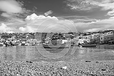 Fishing boats on sea beach in Mykonos, Greece. Sea village on cloudy sky. White houses on mountain landscape with nice Editorial Stock Photo