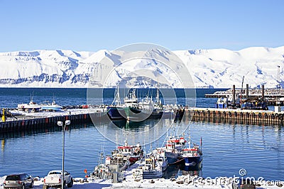 Fishing boats, snowy mountains, blue skies. Husavik harbour, Iceland on a cold winter morning Editorial Stock Photo