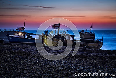 Fishing boats waiting to be launched from Hastings beach before dawn. Editorial Stock Photo
