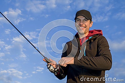 Happy smiling fisherman on clouds background Stock Photo