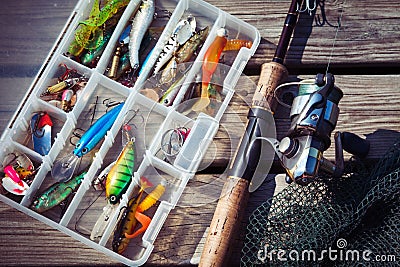 Fishing Lures in tackle boxes with spinning rod and net Stock Photo