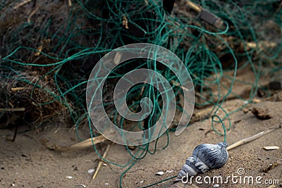 Fishing nets on the beach with a small blue shell Stock Photo