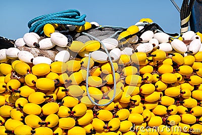 Fishing nets with yellow floats on the pile, close up Stock Photo