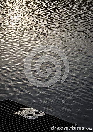 Fishing peg number eighteen with shimmering sunset water in background Stock Photo