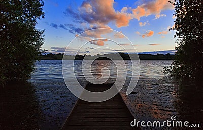 Fishing platform with sunset clouds reflected in Ravensthorpe Reservoir Stock Photo