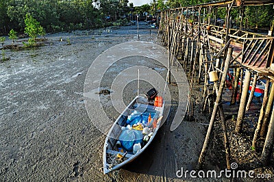 Fishing sampan stranded near to wooden pier Editorial Stock Photo