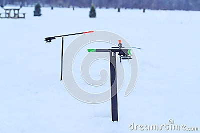 Fishing tackles for winter fishing on ice of a frozen lake. Fishing competition on ice. Great landscape of winter sport and family Stock Photo