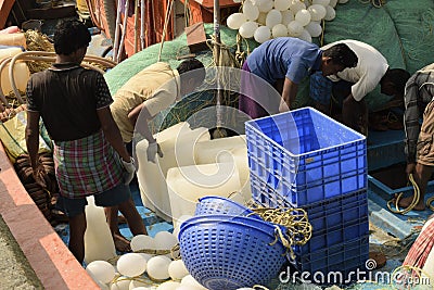 Fishing trawler crew preparing voyage supplies with ice blocks for cargo preservation at Frezarganj Harbor, West Bengal, India Editorial Stock Photo