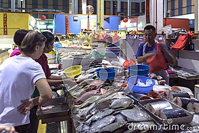 Fishmonger selling fishes at morning wet market Editorial Stock Photo