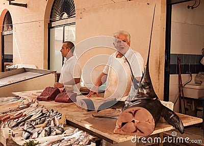 Fishmonger selling swordfish in an old local market Editorial Stock Photo