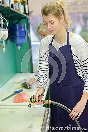 Fishmongers employee cleaning kitchen Stock Photo