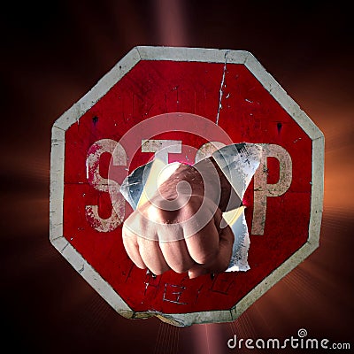 Fist of man punching through red traffic sign with inscription Stop, concept for overcoming, strength, assertiveness Stock Photo