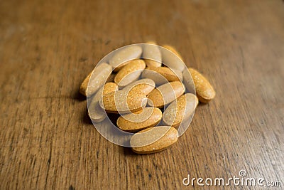 Fistful of multivitamin pills on wood Stock Photo