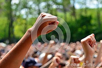 Fists from many people are raised at a protest Stock Photo