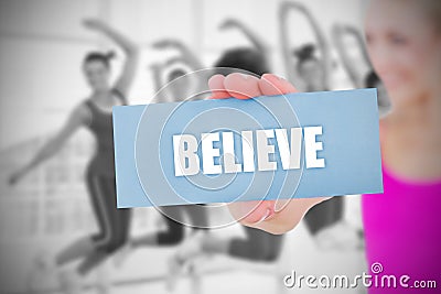 Fit blonde holding card saying believe Stock Photo