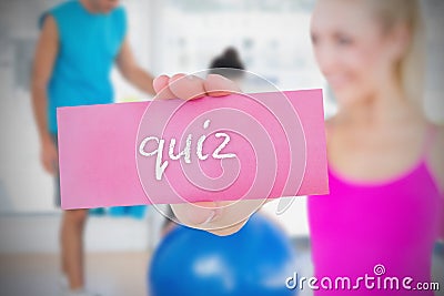 Fit blonde holding card saying quiz Stock Photo