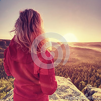 Fit body blond hair woman on the top of the high rock Stock Photo