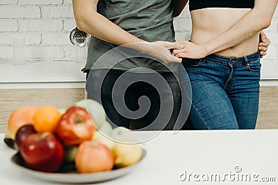 Fit couple snacking with fresh fruits at kitchen Stock Photo