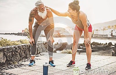 Fit couple taking a rest after fast running workout - Joggers training outdoor at sunset together - Focus on faces - Fitness, Stock Photo