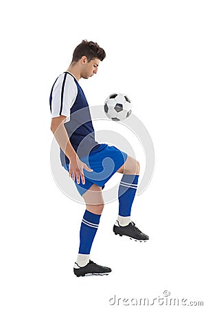 Fit football player playing with ball Stock Photo