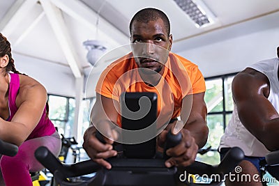 Fit man exercising on exercise bike in fitness center Stock Photo