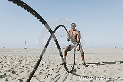 Fit man working out with battle ropes Stock Photo