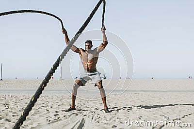 Fit man working out with battle ropes Stock Photo