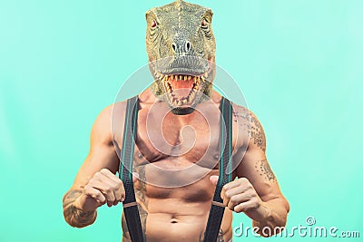 Fit senior man wearing t-rex dinosaur mask - Crazy hipster guy having fun celebrating masquerade carnival holidays Stock Photo