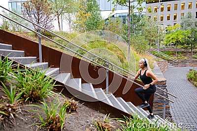 Fit sports women running interval workout in stairs in city park Stock Photo